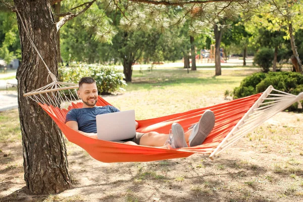 Przystojny Człowiek Laptopem Relaksujący Się Hamaku Świeżym Powietrzu — Zdjęcie stockowe