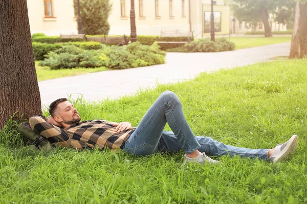 Yakışıklı adam parkta dinleniyor.