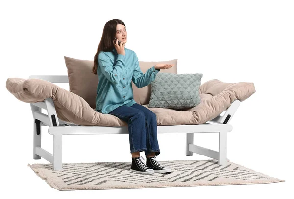 Νεαρή Γυναίκα Μιλάει Στο Τηλέφωνο Ενώ Κάθεται Στον Καναπέ Λευκό — Φωτογραφία Αρχείου