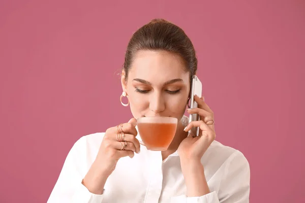 Красивая Молодая Женщина Чашкой Чая Говорить Телефону Цветном Фоне — стоковое фото