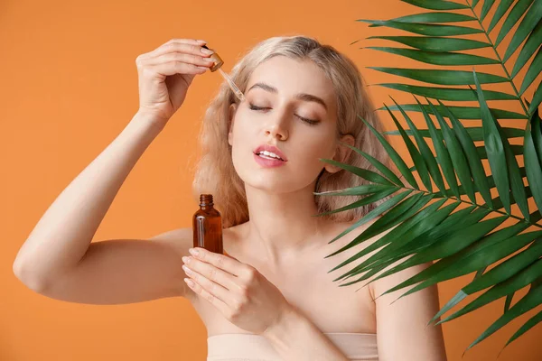 Vacker Ung Kvinna Med Kosmetisk Olja Och Tropiska Blad Färg — Stockfoto