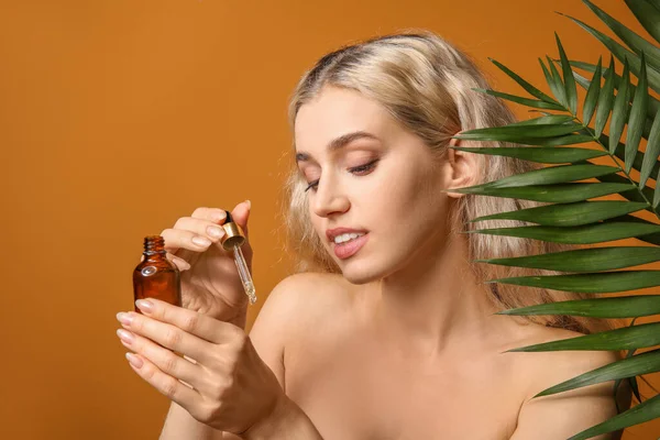 Mulher Bonita Com Óleo Cosmético Folhas Tropicais Fundo Cor — Fotografia de Stock