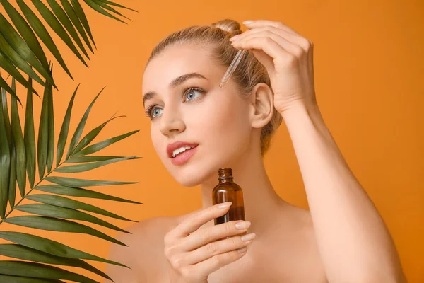 Vacker Ung Kvinna Med Kosmetisk Olja Och Tropiska Blad Färg — Stockfoto