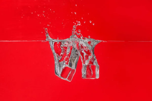氷のキューブの色の背景に水に落ちる — ストック写真