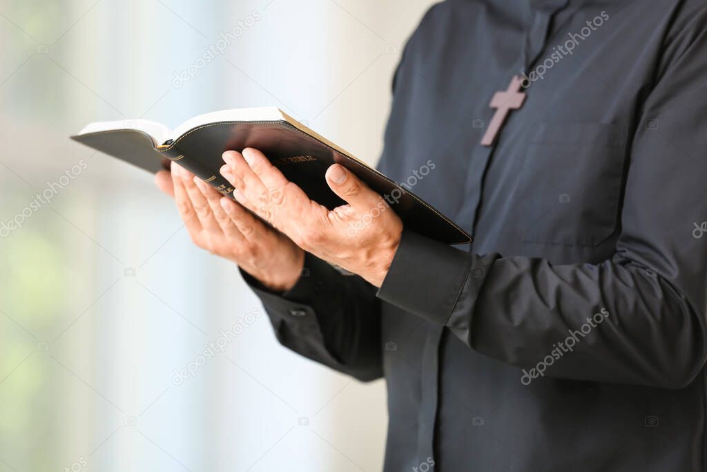 Male priest with Bible at home, closeup