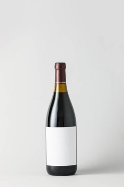 Hafif arka planda boş etiketli bir şişe şarap. Tasarım için model