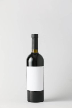 Hafif arka planda boş etiketli bir şişe şarap. Tasarım için model