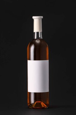 Siyah arka planda boş etiketli bir şişe şarap. Tasarım için model