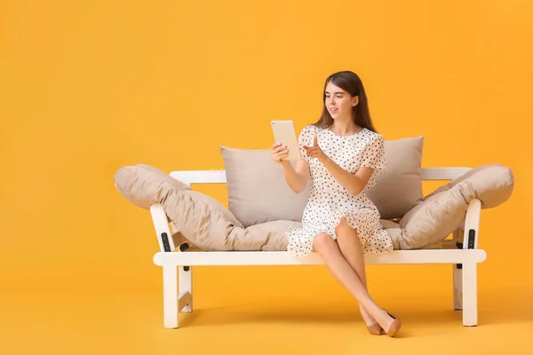 Young Woman Tablet Computer Modern Sofa Color Background — Stock Photo, Image