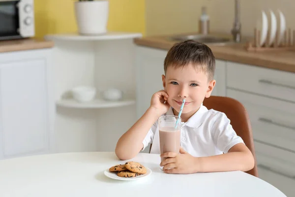 小さな男の子はチョコレートミルクを飲み 家でクッキーを食べる — ストック写真