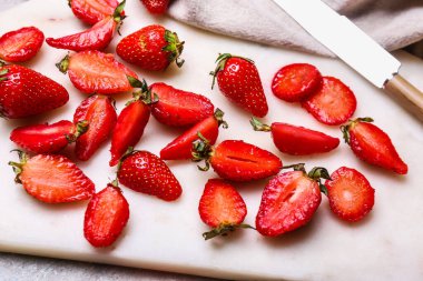Masada taze olgun çilekle kesme tahtası.