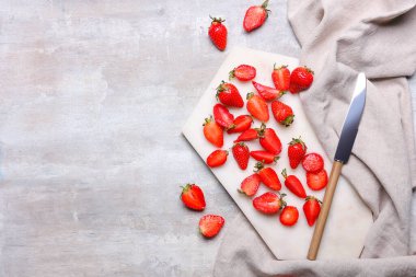 Gri arka planda taze olgun çilekli kesme tahtası.