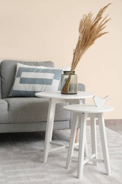 Masaları ve kanepesi olan şık bir oturma odası.