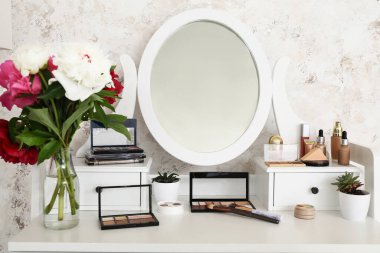 Giyinme odasında makyaj malzemeleri ve aksesuarlı bir masa.