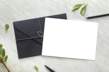 Açık arkaplanda boş kart ve zarf içeren kompozisyon