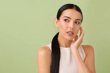 Renkli arka planda güzel göz farları olan genç bir kadın.