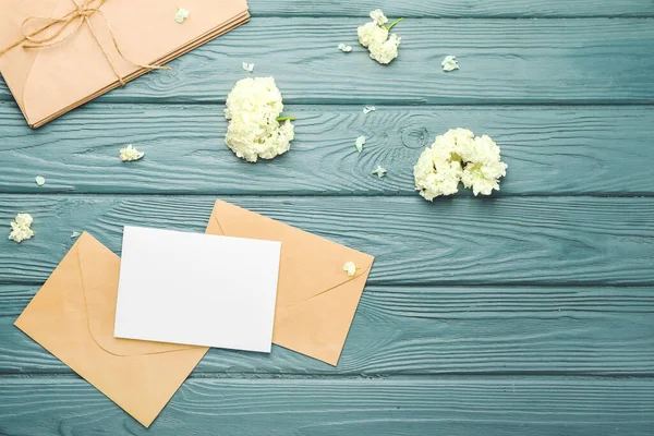 Composition with blank card and envelopes on wooden background
