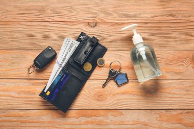 Anahtarlı cüzdan ve ahşap arka planda dezenfektan