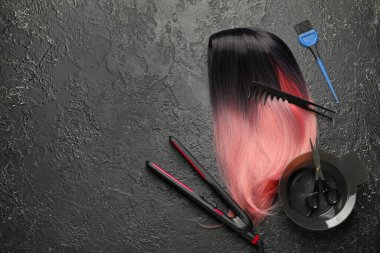 Koyu arkaplanda kuaför malzemeleri olan alışılmadık bir peruk.