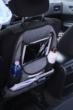 Salondaki araba koltuğunda farklı şeyler olan seyahat organizatörü.