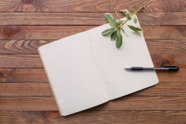 Ahşap zemin üzerinde kalem olan defter