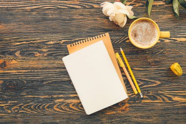 Ahşap zemin üzerinde bir fincan kahve olan farklı bir kırtasiye.