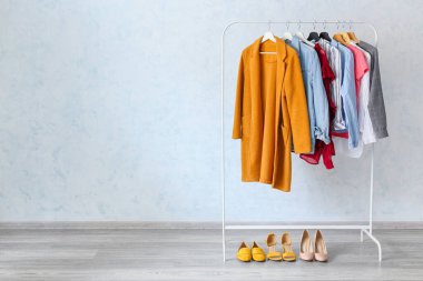 Koridordaki ışıklı duvarın yanında giysilerle dizilin.