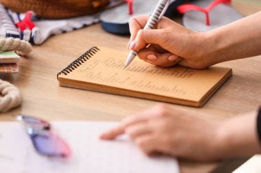Seyahat için toplanacak eşyaların listesini hazırlayan kadın