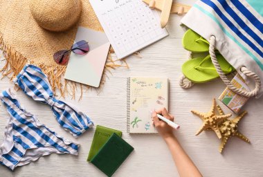 Seyahat için toplanacak eşyaların listesini hazırlayan kadın