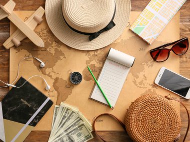 Dünya haritasında seyahat etmek için paketlenecek şeylerin kontrol listesi olan defter