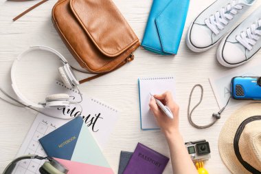 Seyahat için toplanacak eşyaların listesini hazırlayan kadın