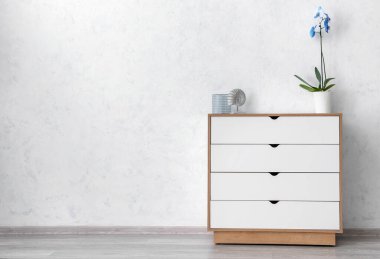 Çekmecelerin modern sandığı, odanın ışık duvarının yanında.