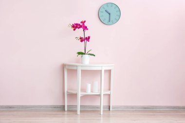 Renkli duvarın yanındaki çiçekli masa.