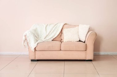 Odanın duvarının yanındaki yumuşak kanepe.