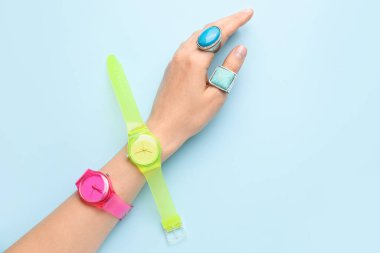 Renkli arka planda şık kol saatleri olan bir kadın el.