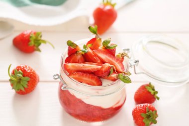 Masada bir kavanoz çilekli yoğurt.