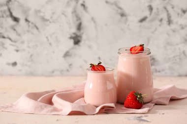 Kavanozlar dolusu çilekli yoğurt masada.