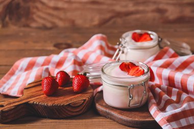 Masada bir kavanoz çilekli yoğurt.