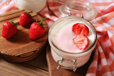 Masada bir kavanoz çilekli yoğurt.