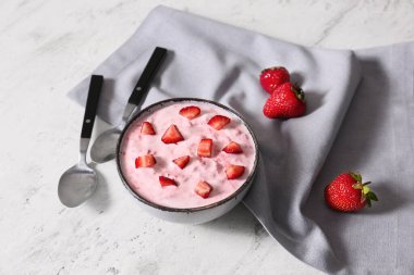 Beyaz arka planda bir kase çilekli yoğurt