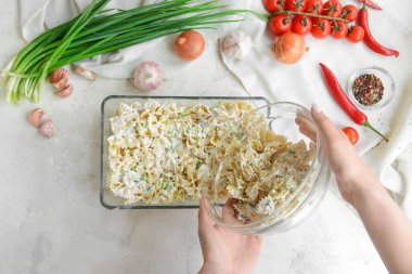 Kadın arka planda leziz makarna hazırlıyor.