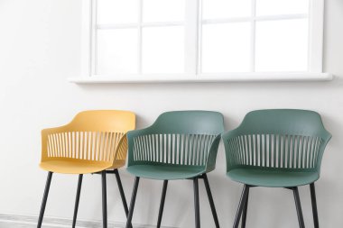 Işık duvarının yanındaki modern sandalyeler