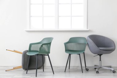 Işık duvarının yanındaki modern sandalyeler