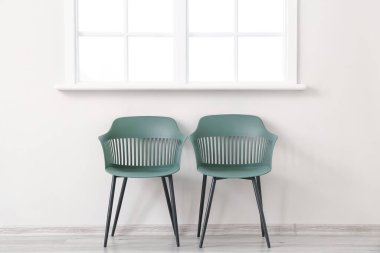 Işık duvarının yanındaki modern sandalyeler