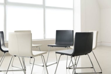 Psikologların ofisinde grup terapisi için hazırlanmış boş sandalyeler.
