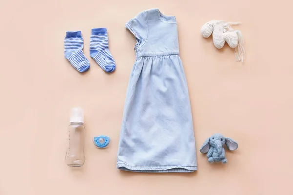 Babykleidung Mit Flasche Schnuller Und Spielzeug Auf Farbigem Hintergrund — Stockfoto