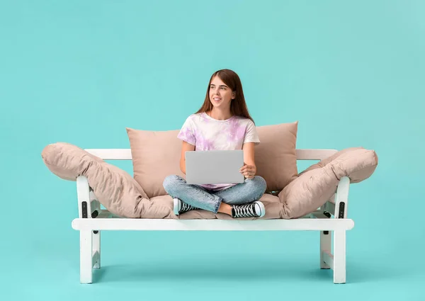 Jovem Mulher Com Laptop Sofá Moderno Contra Fundo Cor — Fotografia de Stock