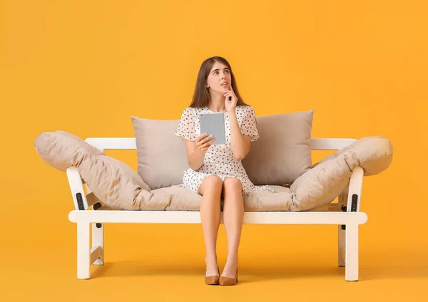 Thoughtful Young Woman Tablet Computer Modern Sofa Color Background — Stock Photo, Image
