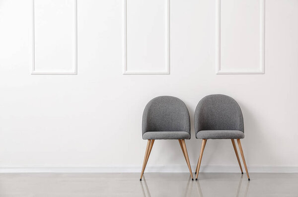 Современные стулья возле светлой стены