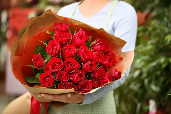 Sprzedawca Bukietem Pięknych Czerwonych Róż Sklepie — Zdjęcie stockowe